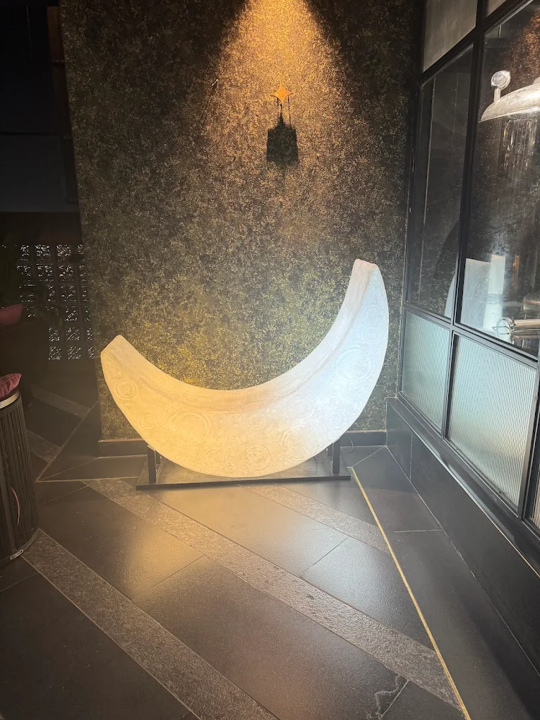 The crescent seat resting unlit in its corner by the window.
