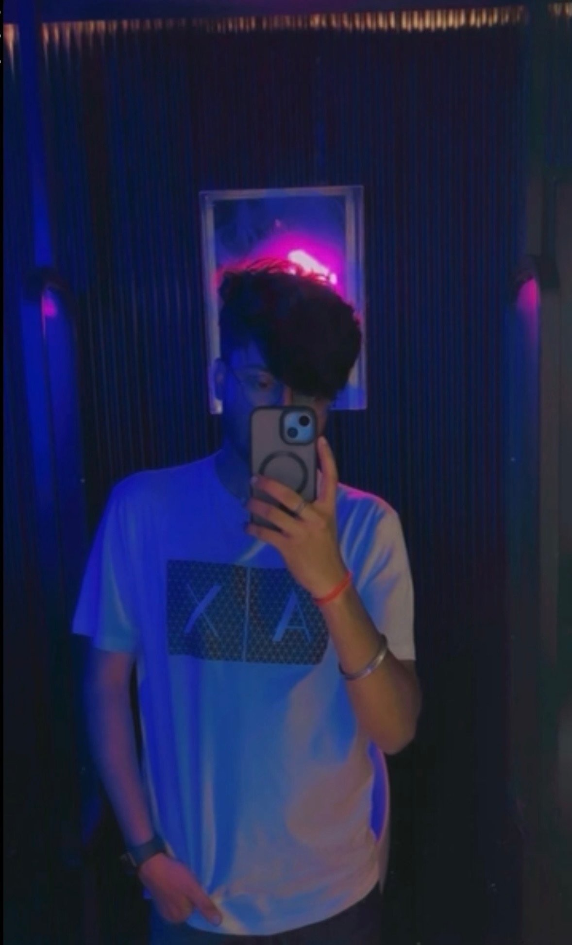 A mirror shot in the lounge corridor, washed in blue and pink neon.